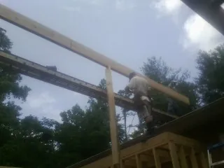 Carpenter setting a ridge beam over a new addition frame — Ice Dam Removal by Roofing Brothers in Wamego