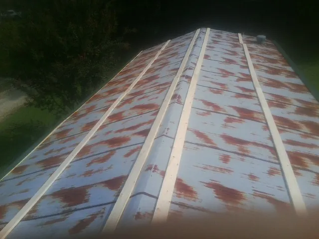 Rusted metal roof panels with new wood purlins before replacement — Storm Damage Roof Repair in Wamego by Roofing Brothers