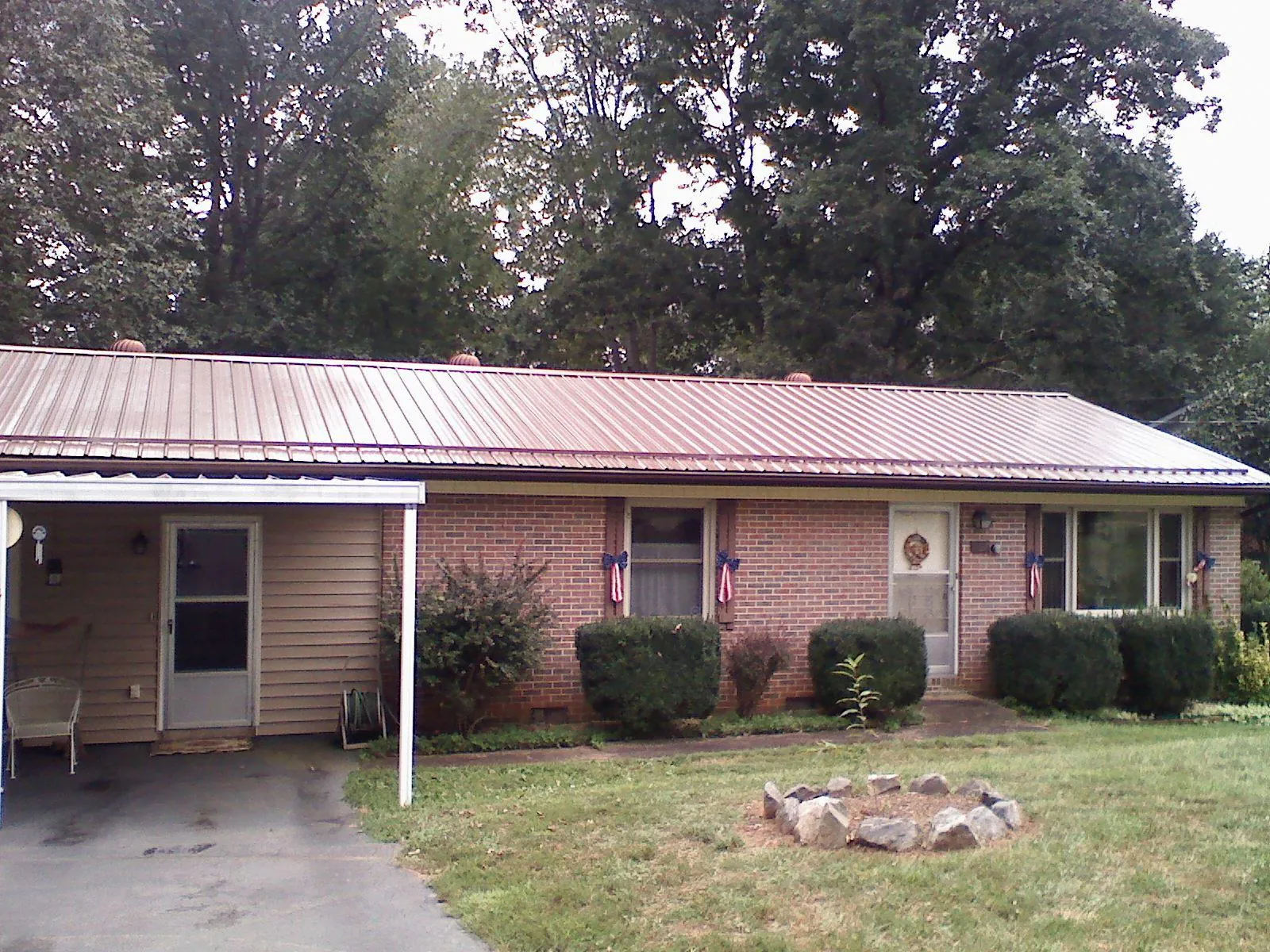 Bronze metal roof and carport on a brick ranch home — Roof Repair work by our crew in Wamego